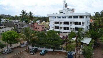 A multi-story building with a flat roof and several air conditioning units.