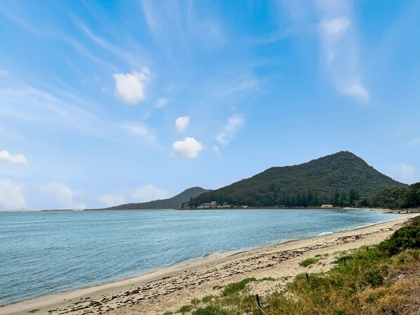 A beach with a mountain in the background and clear skies. - Bella Vista 3 Shoal Bay Apartment with Water Views (Shoal Bay)