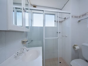 Een badkamer met bad, toilet en douche.