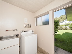 A laundry area with a washing machine, a sink, and a window with frosted glass. - Bella Vista 3 Shoal Bay Apartment with Water Views (Shoal Bay)