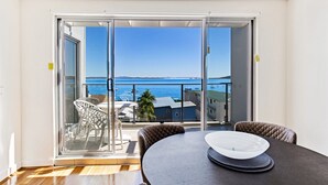 A room with a large sliding glass door leading to a balcony with a view of the sea. - The Shoal 510 panoramic water views (Shoal Bay)