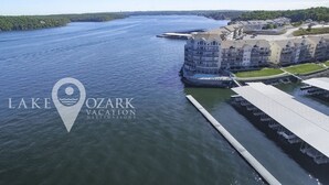 Un hôtel situé au bord de l’eau, doté d’un quai, d’un grand bâtiment avec de nombreux balcons et offrant une vue dégagée sur le lac.