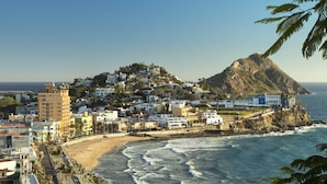 A coastal town with buildings on a hillside overlooking the sea. - Hotel Boutique Casa Lulu (Mazatlán)