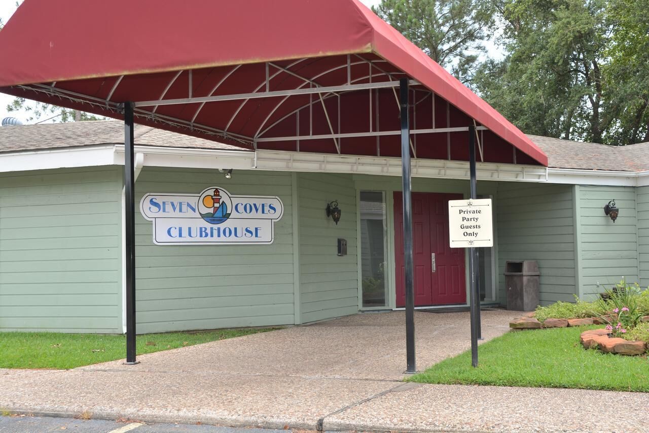 Un bâtiment sur lequel on peut lire l’inscription « SEVEN COVES CLUBHOUSE » et un panneau indiquant « Réservé aux invités d’une réception privée ».