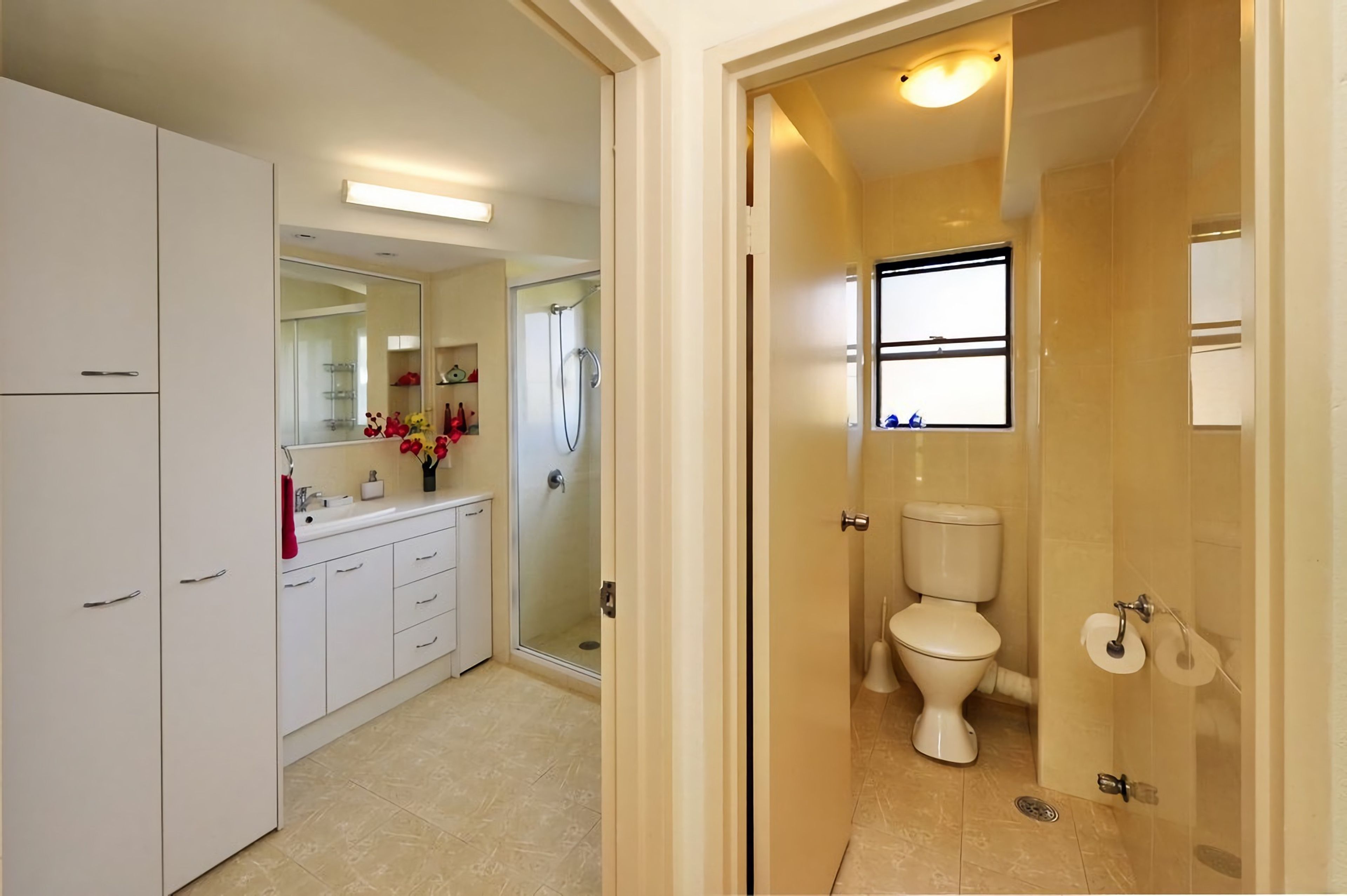 A bathroom with a toilet, a shower, and a sink.