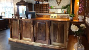 Un mostrador de recepción con detalles de madera, una computadora y un enfriador de vinos.