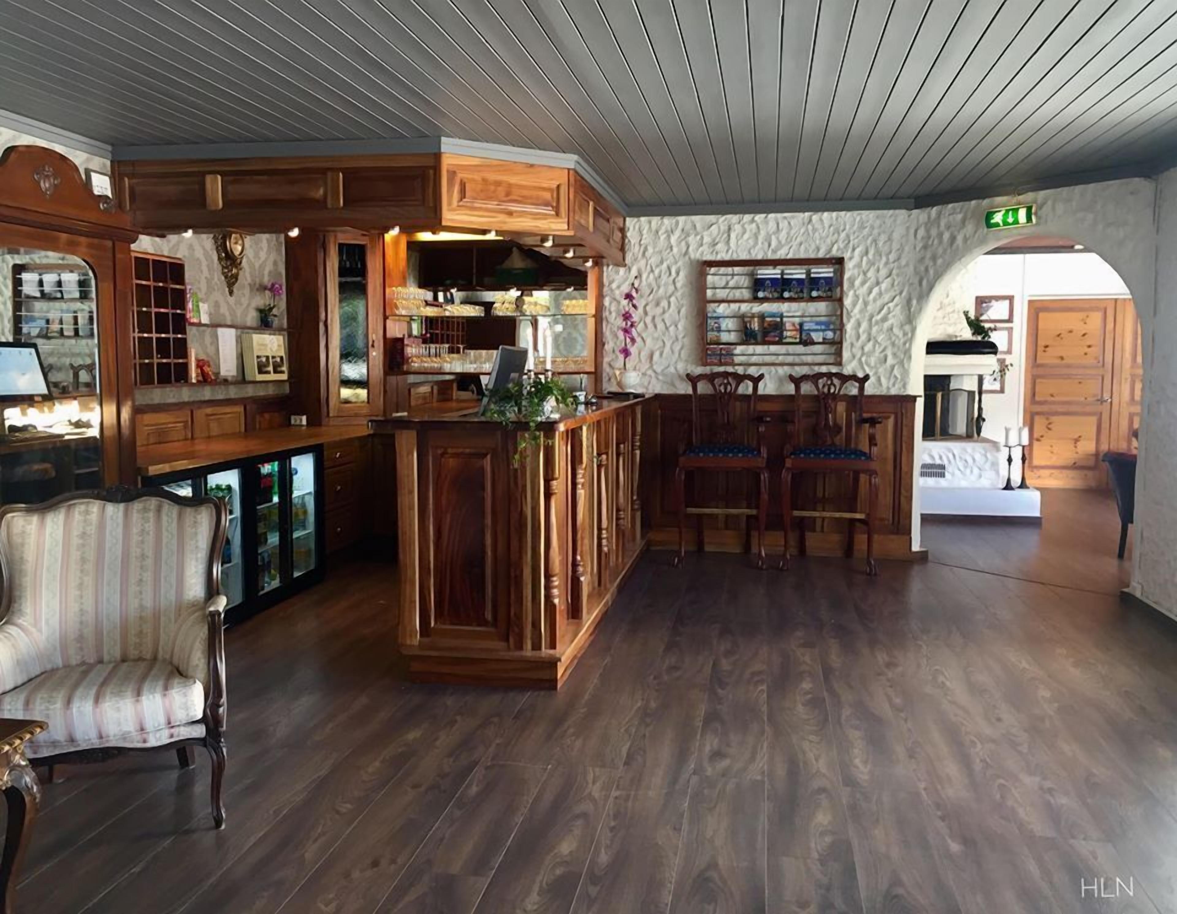Um quarto espaçoso com um bar de madeira, conjunto de jantar e parede estampada.