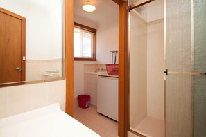 Een kleine badkamer met een douche, toilet en wastafel.