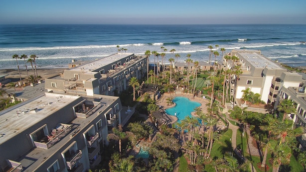 A resort with multiple buildings, a swimming pool, and a view of the ocean. - Pier View Escape (Oceanside)