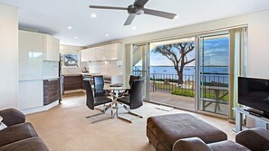 A modern apartment with a balcony, a dining area, and a living room.