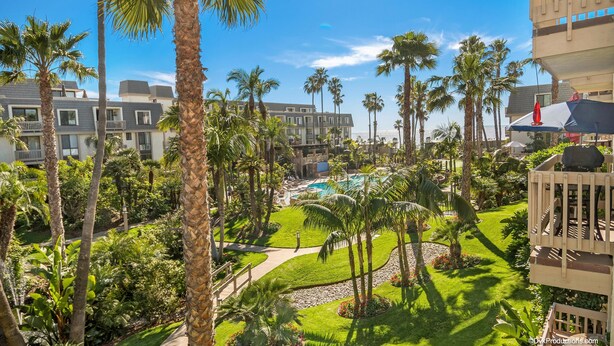 A resort with a pool, palm trees, and a view of the ocean. - North Coast Village F-200 Beach Oasis (Oceanside)