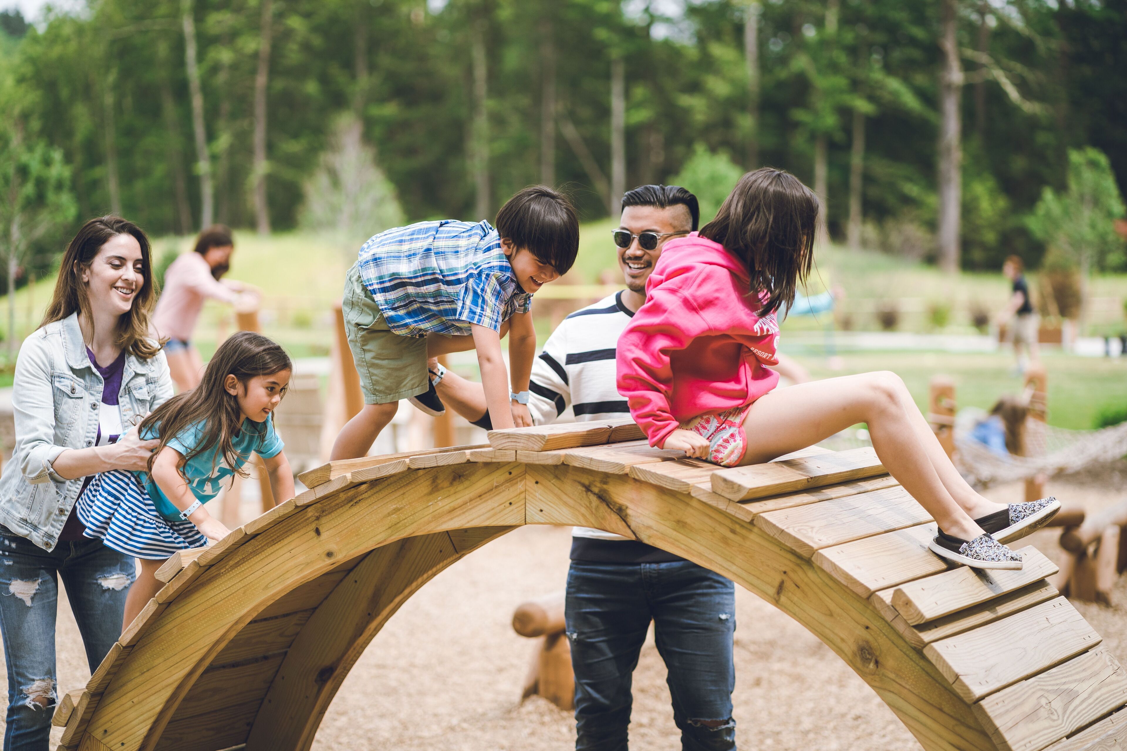 A group of people at an outdoor wooden structure in a park.