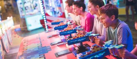 A row of arcade machines with colorful lights and joysticks.