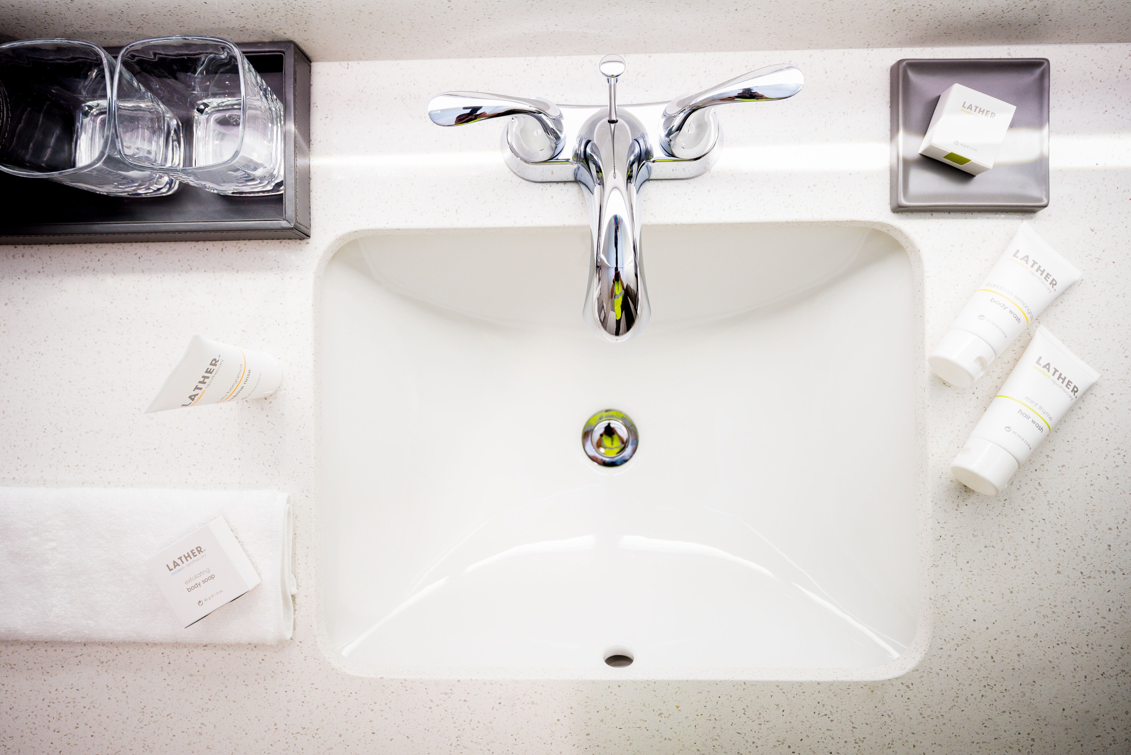 A bathroom sink with a chrome faucet, a soap dish, and toiletries.