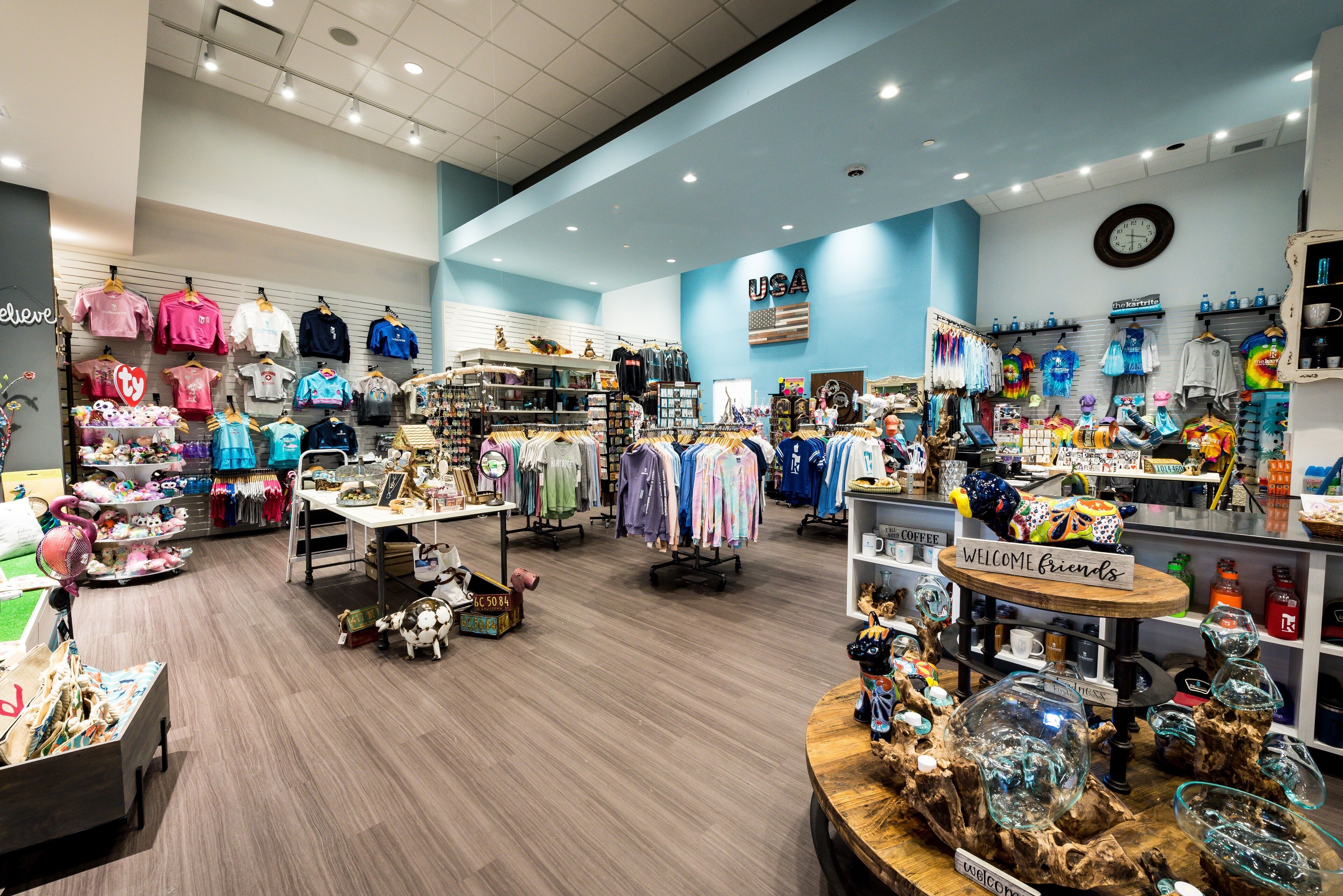 A brightly lit retail store with various clothing items and accessories displayed on shelves and racks.