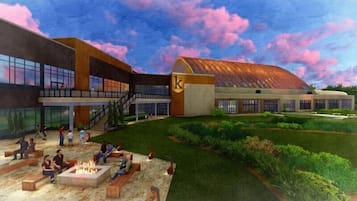A modern building with a large open courtyard, outdoor seating, and a fire pit area.