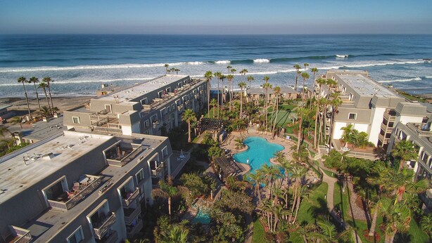 A resort with multiple buildings, a swimming pool, and a view of the ocean. - Pacific Palms (Oceanside)