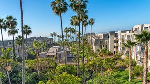 A residential area with multiple apartment buildings, surrounded by lush greenery and palm trees. - Pacific Palms (Oceanside)
