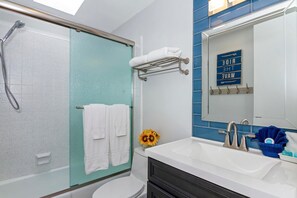 Une salle de bain équipée d’une douche, de toilettes, d’un lavabo et d’un porte-serviettes avec des serviettes.