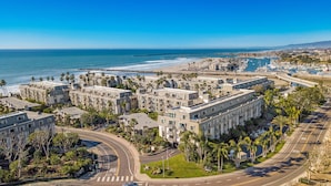 A coastal residential area with modern apartment buildings, a marina, and a beach. - Paradise Found (Oceanside)
