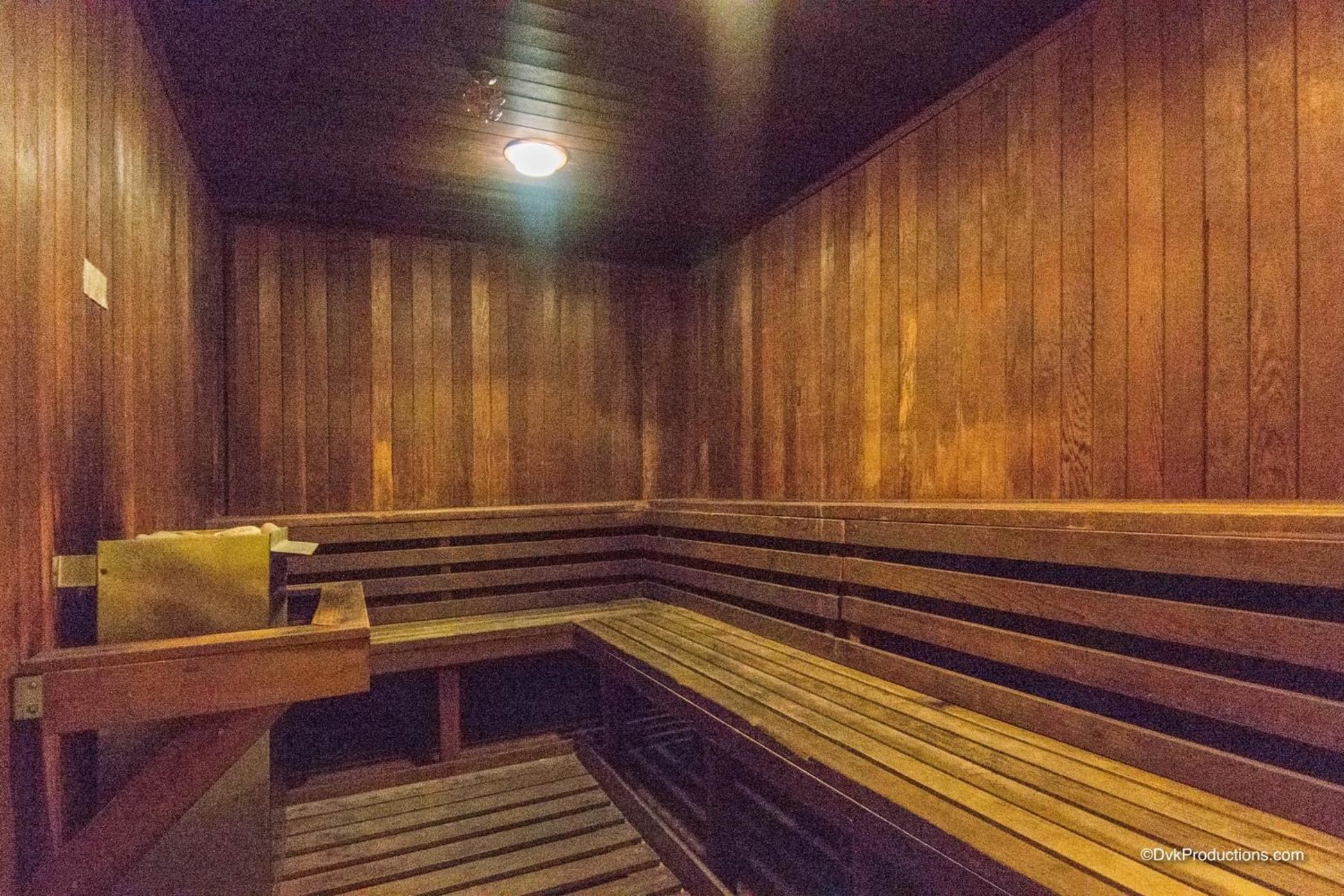 A sauna with wooden benches and a bench with a towel.