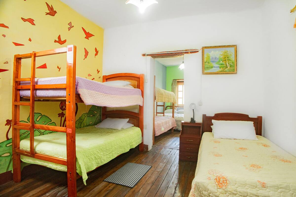 A room with bunk beds, a desk, and a chair.