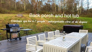 An outdoor patio with a hot tub and grill, seating for 6-7 people, and a view of ski slopes. - Newly Renovated 5 Bedroom Home with Gorgeous Views just minutes from Slopes (Hunter)