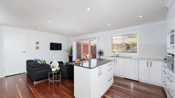 A modern kitchen with white cabinets, a black countertop, and a built-in oven. - Eden by the Bay, 98 Sandy Point Rd - Large family home just 300m to Corlette Beach (Corlette)