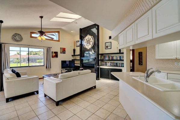 A modern living room with a sofa, a television, and a fireplace.