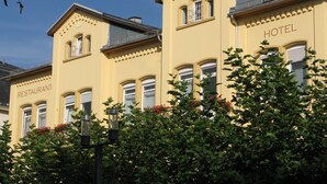 Ein gelbes Gebäude mit einem Schild, auf dem rechts das Wort 'HOTEL' steht.