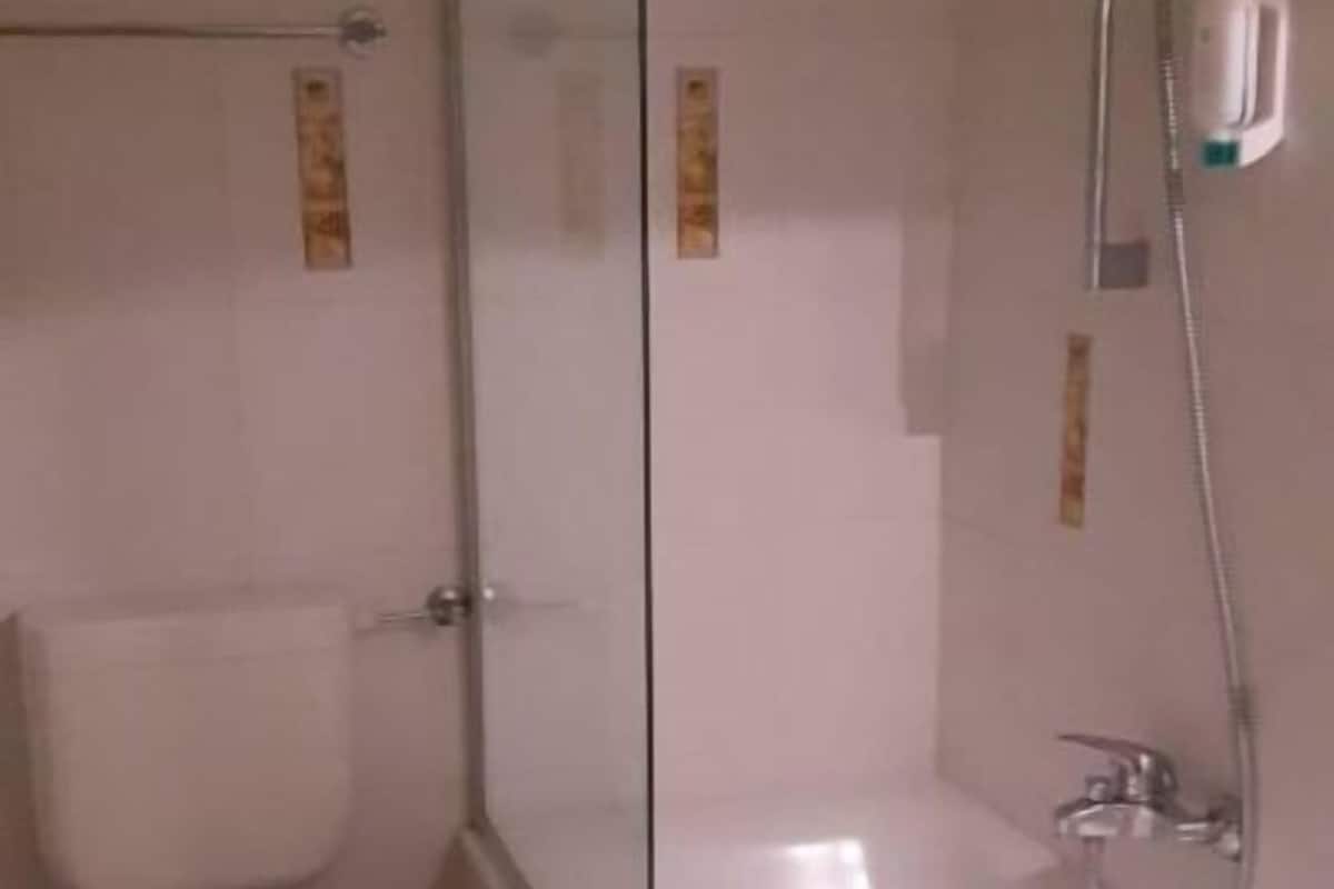 A bathroom with a toilet, a glass-enclosed shower, and a bathtub.