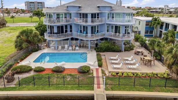A multi-story building with balconies, a swimming pool, and outdoor seating areas. - Amadeus 2 Top location, water font, steps to beach, restaurants and shopping! (Treasure Island)