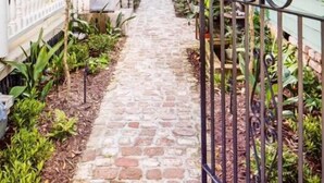 A narrow stone pathway flanked by two-story houses with a metal fence on one side. - 69B Spring Street - 2 BR / 1 BA Holiday home 2 (Charleston)
