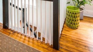 A staircase with a black railing, a woven wall decoration, a hanging light fixture, and a green plant in a patterned pot. - 69B Spring Street - 2 BR / 1 BA Holiday home 2 (Charleston)