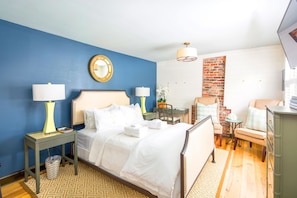 A hotel room with a bed, bedside tables, a desk, a chair, and a TV. - 154 E Spring Street - 1 BR / 1 BA Holiday home 1 (Charleston)