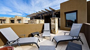 Eine Außenpatio mit Lounge-Möbeln und einer Pergola.