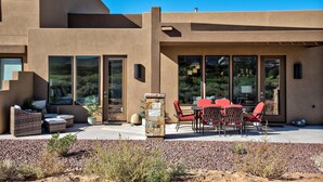 A modern house with a patio, outdoor furniture, and a stone pillar. - Quail Corner (St. George)