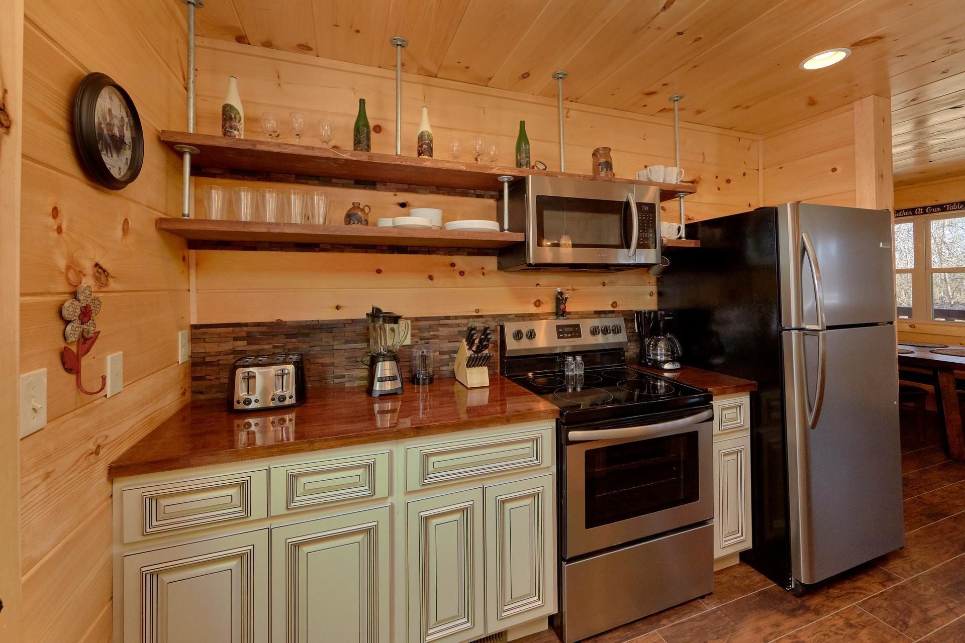 A kitchen with wooden cabinets, a stove, a microwave, and a refrigerator.