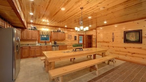 A wooden cabin-style kitchen with a large dining table and benches, wooden cabinets, and a refrigerator. - Paradise Point Pool Lodge Holiday home 6 (Sevierville)