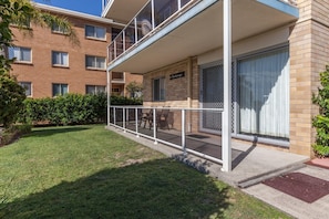 Un edificio residencial de dos pisos con un balcón, un pequeño jardín y una puerta visible con la leyenda 'Castaways'.
