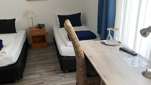 A hotel room with two beds, a desk, a chair, a TV, and a window with curtains. - Hotel Restaurant Cala Luna (Marburg)