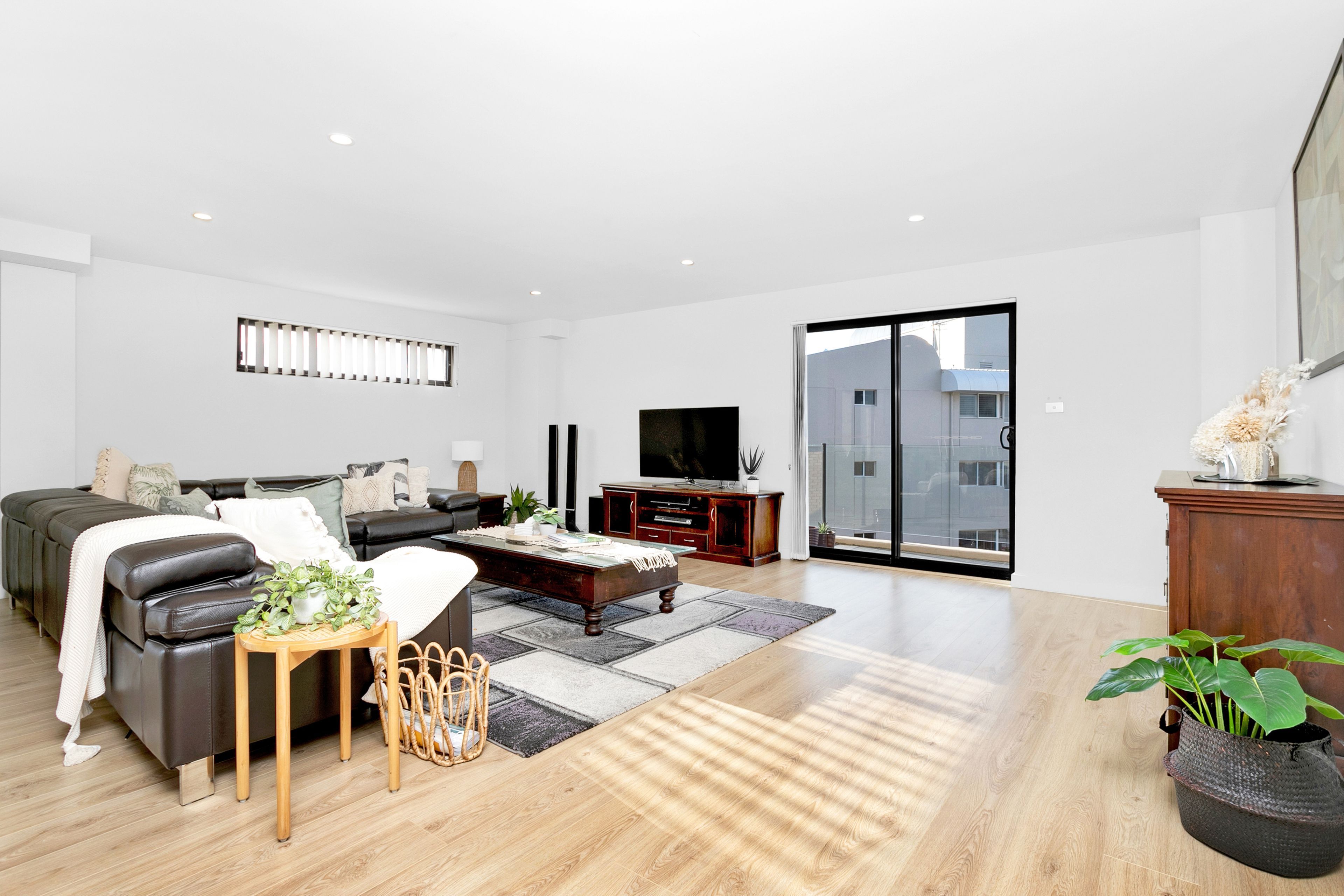 Ein modernes Wohnzimmer mit Sofa, Couchtisch und Unterhaltungseinheit.