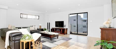 Een moderne woonkamer met een bank, salontafel en een tv-meubel.