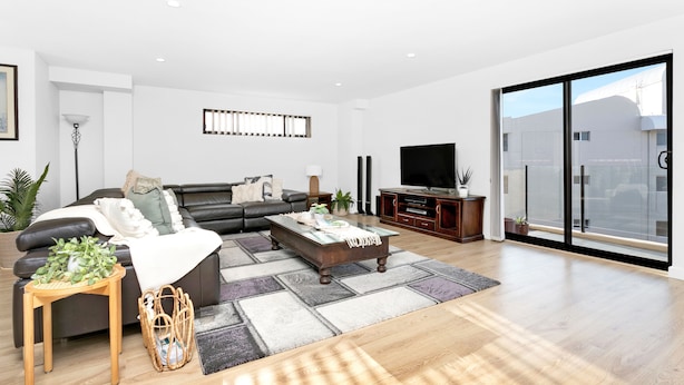 A modern living room with a sofa, coffee table, and TV. - Dolphin Cove 13 Luxury Apartment in Nelson Bay (Nelson Bay)