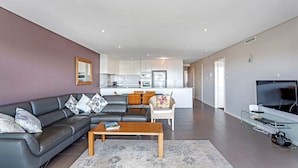 A modern living room with a sofa, coffee table, and a TV.