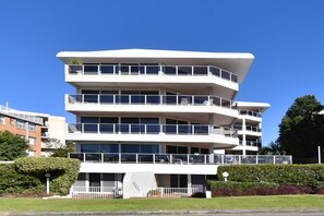 A multi-story building with balconies and large windows.