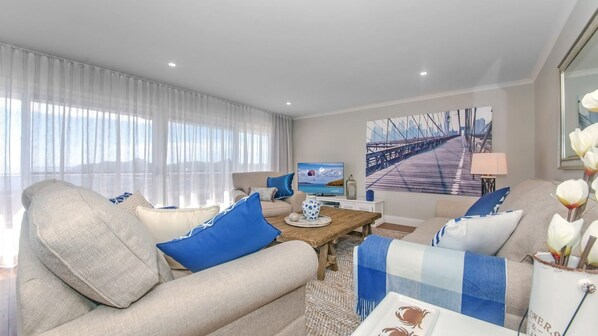 A modern living room with a sofa, coffee table, and a television.