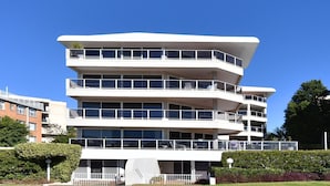 Un edifici d'àmbit urbà amb balcons, grans finestres i terrat pla.