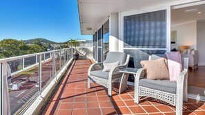 A balcony with wicker furniture, a view of the city, and a tiled floor. - Right in Nelson Bay with views over the Marina (Nelson Bay)