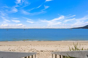 A beach with a clear sky, calm sea, and a sandy shore. - Bella Vista 22 Waterfront Apartment in Shoal Bay (Shoal Bay)